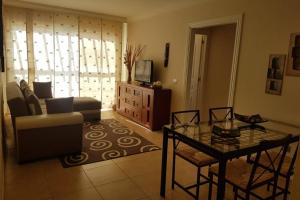 ein Wohnzimmer mit einem Sofa und einem Tisch in der Unterkunft Residencial Cary II - Apartamento Familiar in Poris de Abona