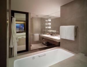 a bathroom with a tub and a sink and a mirror at Grand Hyatt Hong Kong in Hong Kong
