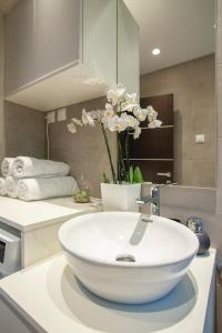 baño con lavabo blanco y flores en una encimera en Vila Sofija, en Kotor