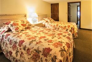 ビロクシにあるRoyal Holiday Beach Resortのホテルルーム 花の飾られたベッド2台付