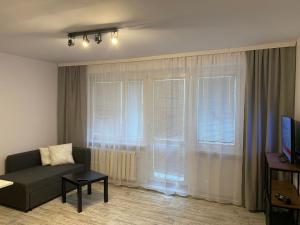 a living room with a couch and some windows at 123 Aurora Bydgoszcz in Bydgoszcz