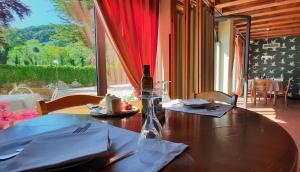 een houten tafel met een fles wijn erop bij Agriturismo La Bella in Follina