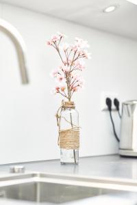 a vase filled with pink flowers sitting on a counter at Sonnhof - Luxus Alpine Penthouse in Bad Wiessee