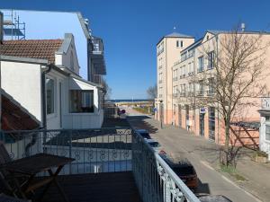 een balkon met uitzicht op een straat en gebouwen bij Hotel Zum Strand in Warnemünde