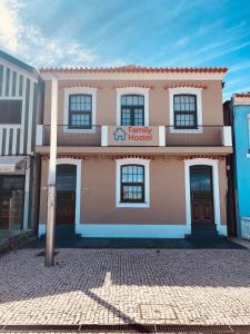 um edifício cor-de-rosa com um cartaz. em Family Hostel Costa Nova em Costa Nova