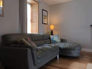 a living room with a leather couch and a window at Village Way Apartments in Kincasslagh