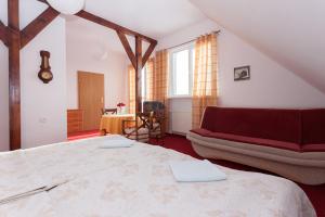 a bedroom with a large bed and a couch at Dom Gościnny Sand in Rewal