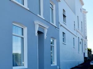 プリマスにあるOne Caprera Guest Houseの青い通りに面した窓のある建物