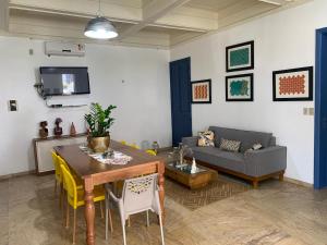 uma sala de estar com uma mesa e um sofá em Porto das Palmeiras Hostel em Salvador