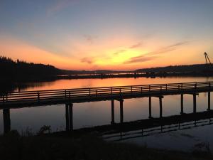 a bridge over a body of water at sunset at Humpback Inn in Port McNeill