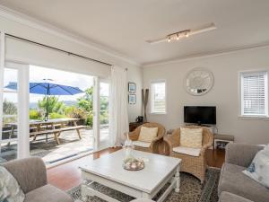 un soggiorno con divano e tavolo di Blue Peter - Opua Holiday Home a Opua