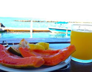 un plato de fruta y un vaso de zumo de naranja en Anchorage Beach Resort, en Lautoka