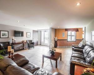 a living room with leather couches and a tv at Econo Lodge Inn & Suites in Montmagny