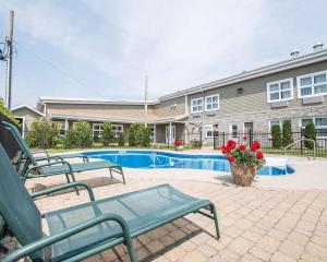蒙馬尼的住宿－Econo Lodge Inn & Suites，一座建筑前的游泳池,设有两个绿色长椅