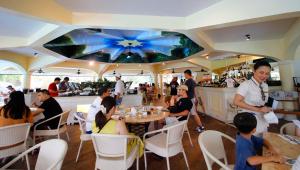 um grupo de pessoas sentadas num restaurante em Plantation Bay Resort and Spa em Mactan