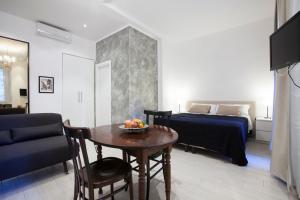 ein Zimmer mit einem Tisch und ein Schlafzimmer mit einem Bett in der Unterkunft Guesthouse Sant'Angelo in Rom