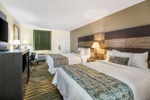 a hotel room with two beds and a television at Rodeway Inn in Cadiz