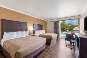 a hotel room with two beds and a television at Quality Inn in Gastonia