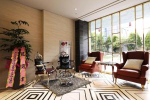 a lobby with chairs and tables and windows at El Tower Hotel in Gunsan