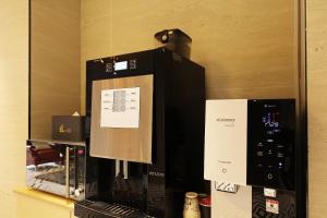 a coffee machine with a sign on the side of it at El Tower Hotel in Gunsan