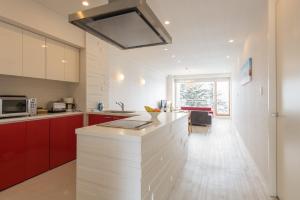 uma cozinha com armários vermelhos e um balcão branco em Niseko Landmark View em Niseko