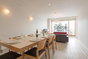 a dining room with a long table and chairs at Niseko Landmark View in Niseko