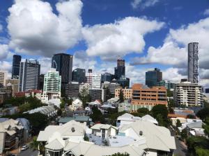 a cityscape of a city with buildings and clouds at The Sedgebrook On Leichhardt in Brisbane
