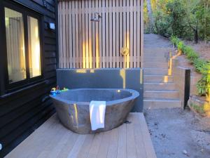 a bath tub sitting outside of a house at The Point Luxury Villa in Taupo