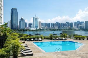 une piscine avec une vue sur les toits de la ville en arrière-plan dans l'établissement Marco Polo Xiamen, à Xiamen