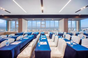 杭州市にあるHoliday Inn Express Hangzhou Westlake East, an IHG Hotelの青いテーブルと椅子、窓が備わる客室です。