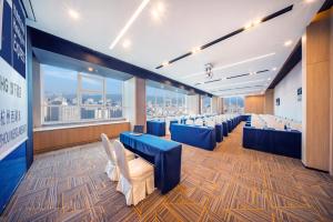 een conferentieruimte met blauwe stoelen en een groot raam bij Holiday Inn Express Hangzhou Westlake East, an IHG Hotel in Hangzhou