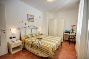 sypialnia z łóżkiem z kapeluszem w obiekcie Residence Villa Andrea w mieście Marina di Camerota