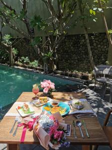 a table with food on it next to a pool at Rumah Batu Boutique Hotel in Solo
