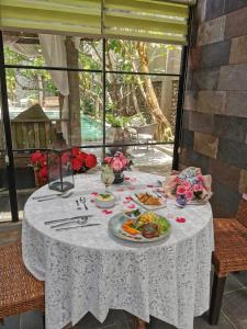 a white table with plates of food on it at Rumah Batu Boutique Hotel in Solo