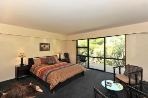 um quarto com uma cama e uma grande janela em Twin Waters Lodge em Collingwood