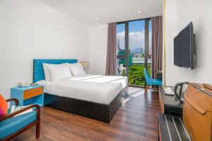 a hotel room with a bed and a tv at Platinum Danang Hotel in Da Nang