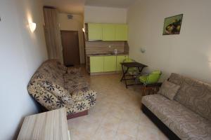 een woonkamer met een bank en een keuken bij Menada Negresco Apartments in Elenite