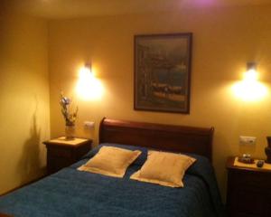 a bedroom with a blue bed with two pillows at As Chivas in Redondela