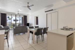 a kitchen and living room with a table and chairs at Park Regis City Quays in Cairns