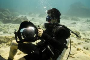 a person taking a picture of a diver in the water at Cardamon Hotel Nilaveli in Nilaveli