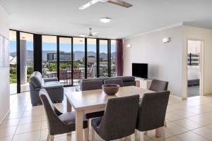 a living room with a dining room table and chairs at Piermonde Apartments Cairns in Cairns