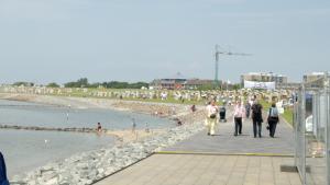ビューズムにあるHaus Tertius - Strand- und hafennahe ruhige Ferienwohnungの海岸を歩く人々