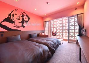 宮古島にあるホテル ピンク・ハイビスカスのベッドルーム1室(ベッド1台、大きな窓付)