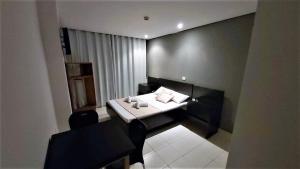 a room with a bed and a table and a chair at Hotel Golden Vilage Vila Maria in São Paulo