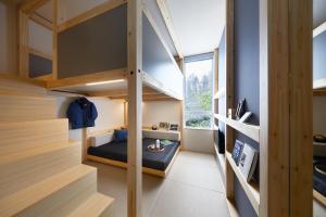 Cette petite chambre comprend des lits superposés et une fenêtre. dans l'établissement Hoshino Resorts BEB5 Karuizawa, à Karuizawa