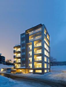 um edifício alto com luzes acesas na neve em Kizuna em Niseko