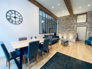 a dining room with a table and chairs and a clock at Hyper centre : Appartement Déco Atelier ou Studio Mezzanine in Lyon