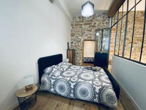 um quarto com uma cama num quarto com uma parede de tijolos em Hyper centre : Appartement Déco Atelier ou Studio Mezzanine em Lyon