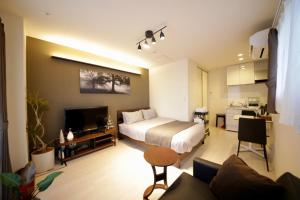 a bedroom with a bed and a living room at Frieden Haus in Tokyo