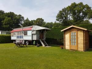 een klein huisje en een schuur in een tuin bij Zigeuner wagen in Oostvoorne